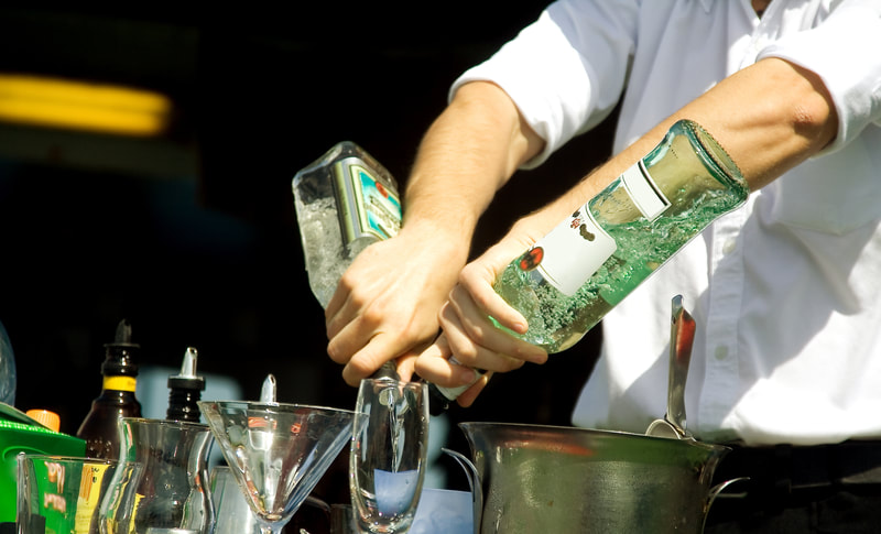 Bartending staff pouring liquor for a cocktail